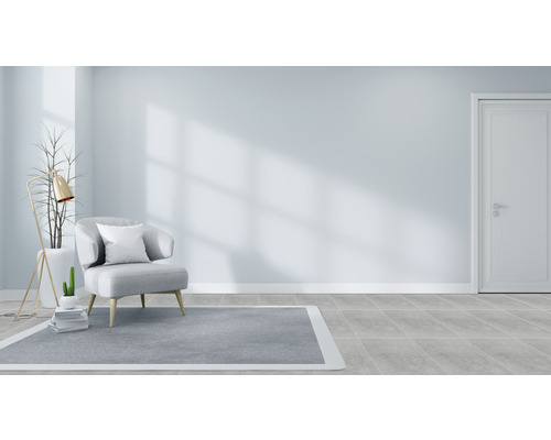 Ljust rum med fåtölj, matta och golvlampa