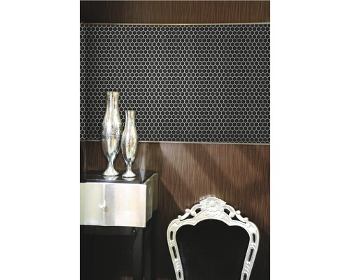 Scen med hexagonformade mosaikplattor på väggen, kombinerat med ett sidobord och en stol