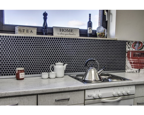 Köksscen med mosaikplattor, tekanna, vattenkokare och spishäll.