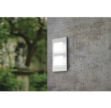 Vägglampa med två kvadratiska lampor på en betongvägg