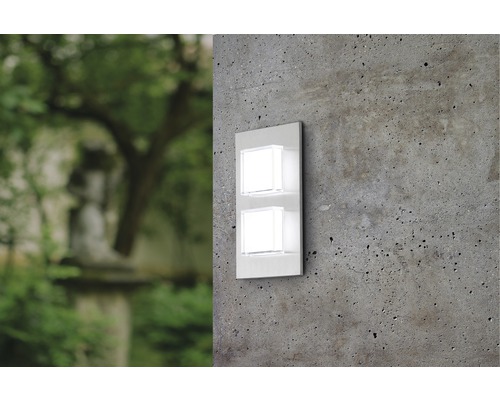 Vägglampa med två kvadratiska lampor på en betongvägg