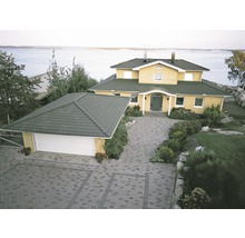 Vy från ett hus med garage och stenlagd uppfart.