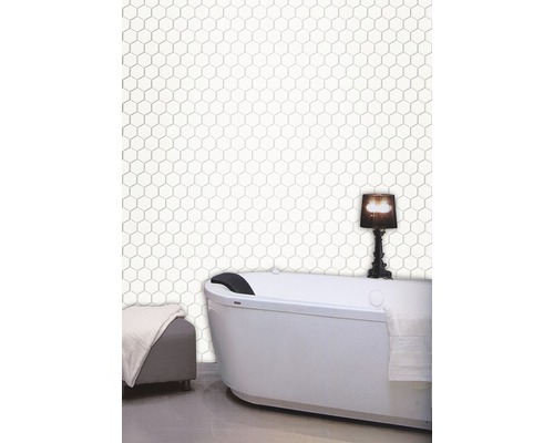 Badrum med fristående badkar och hexagonala plattor på väggen