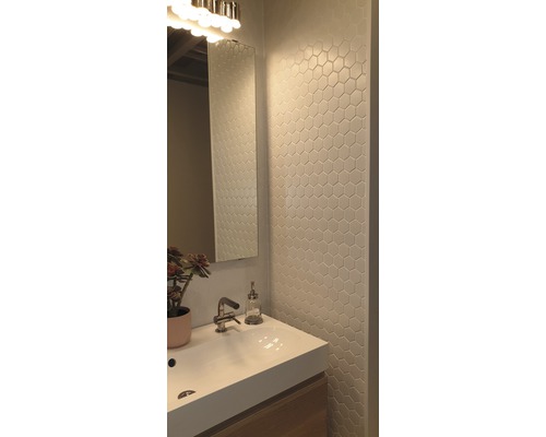 Badrum med handfat, spegel och sexkantiga plattor