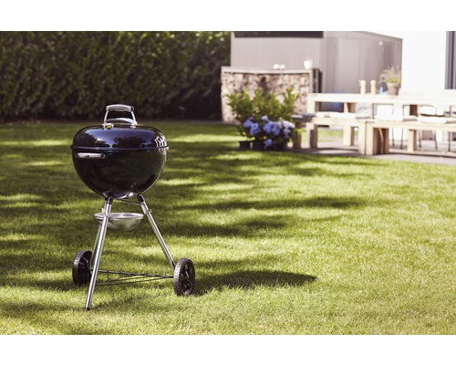 Klotgrill på en gräsmatta i trädgården