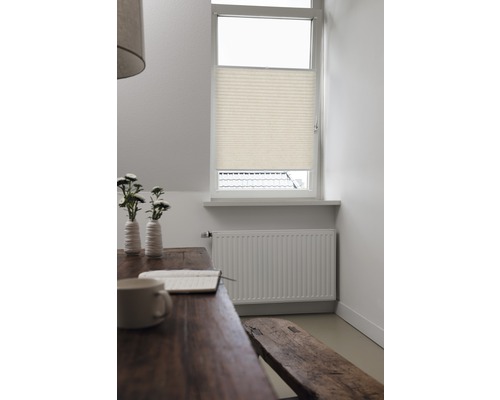 Miljöbild med plisségardin vid fönstret, bord, bänk och element