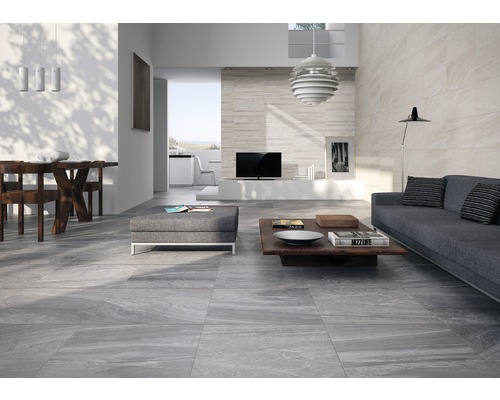 Ljust vardagsrum med soffa, bord och golvplattor