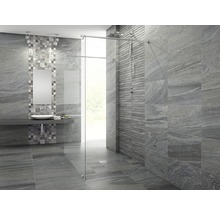 Modernt badrum med gråa kakelplattor, dusch med glasvägg och handfat med spegel