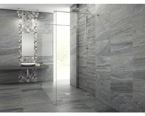 Modernt badrum med gråa kakelplattor, dusch med glasvägg och handfat med spegel