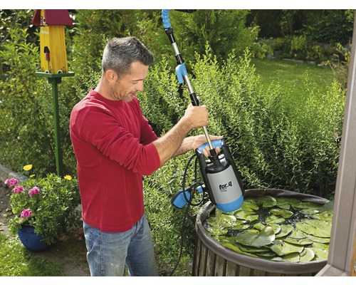 Man använder en dammpump från for_q i en trädgårdsdamm