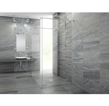 Badrum med grå plattor, handfat, spegel och dusch med glasvägg