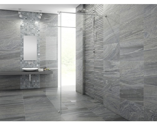 Badrum med grå plattor, handfat, spegel och dusch med glasvägg