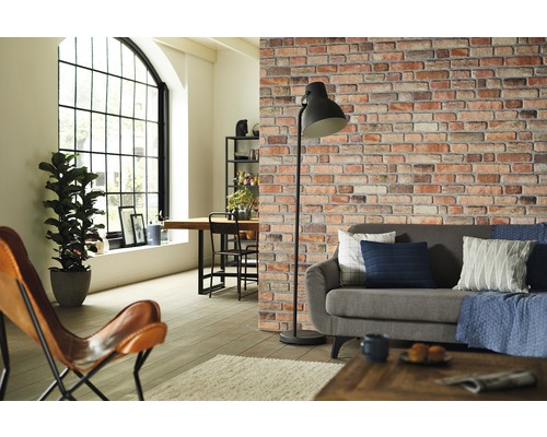 Vardagsrum med soffa, golvlampa och tapet med tegelstensmönster