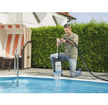 Man använder en dränkpump vid poolen för att tömma vatten.