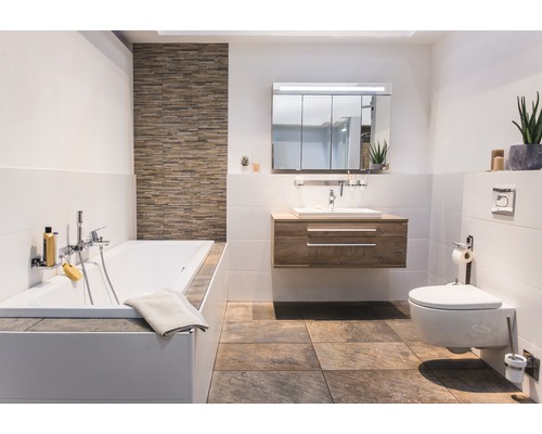 Ljust badrum med badkar, tvättställ, spegelskåp och toalett