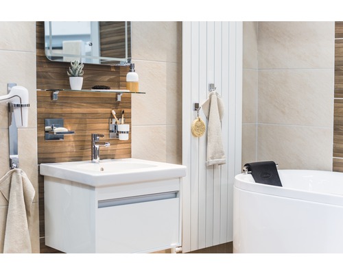 Badrum med tvättställ, spegel, hylla, handdukstork och badkar