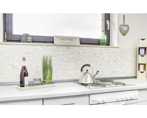 Ljust kök med kakelvägg, drycker och köksredskap på arbetsbänken