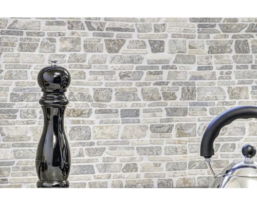 Vägg av stenimitation med pepparkvarn och vattenkokare