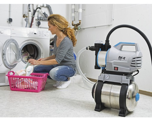 Hydrofor i drift i tvättstugan bredvid en tvättmaskin med tvättkorg
