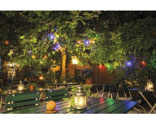 Restaurangträdgård med bord, bänkar och ljusslingor