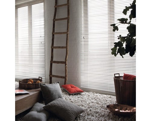 Ljust rum med vita persienner, stege och dekorativa element.