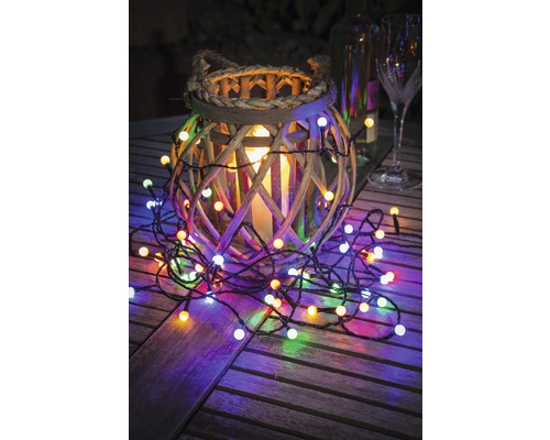 Dekoration med trälykta, ljus och ljusslinga på träbord