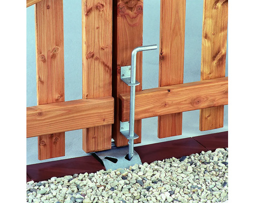 Detaljvy av en trädgårdsport med ett silverfärgat grindlås för säkerhet