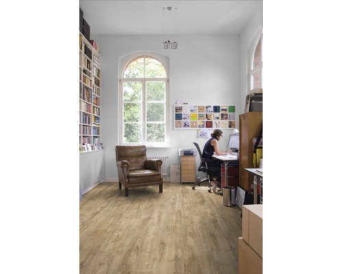 Ljust arbetsrum med bokhylla, fåtölj och laminatgolv
