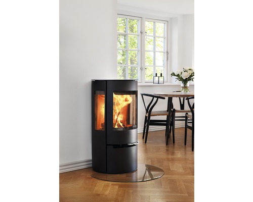 Braskamin med golvplatta av glas i ett ljust rum.