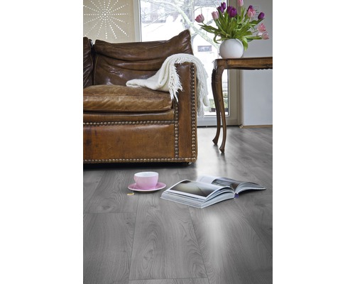 Vardagsrum med skinnsoffa, bord, tulpaner och laminatgolv.