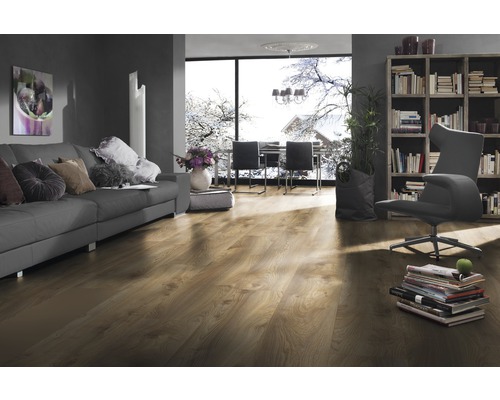 Vardagsrum med laminatgolv, soffa, bokhylla och fönster med vinterlandskap