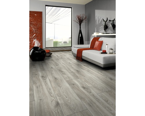 Ljust vardagsrum med laminatgolv i trälook, soffa, fönster och dekoration