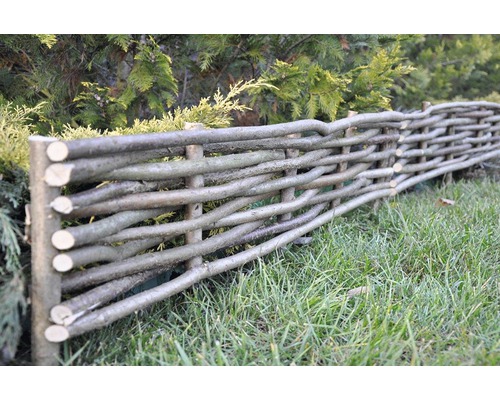 Staket av flätade grenar i trädgården