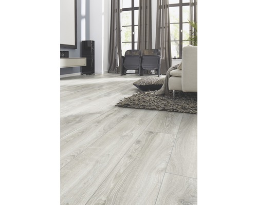 Ljust vardagsrum med laminatgolv i trälook, soffa och matta