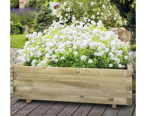Träplanteringslåda med vita blommor i trädgården