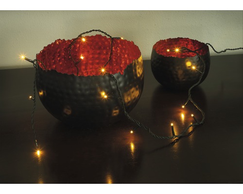 Dekorativa skålar med ljusslinga på ett bord