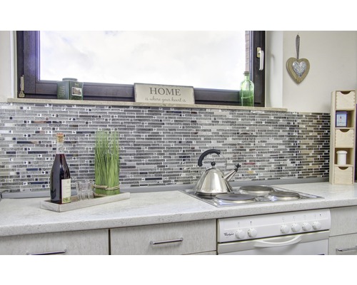 Köksscen med mosaikplattor, kokplatta, tekanna och dekorationer