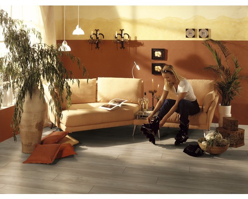 Vardagsrum med soffa, krukväxter och en kvinna som tar på sig inlines