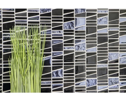 Mosaikplattor i svart och grått med en grön dekoration.