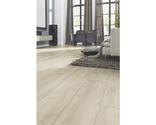 Vardagsrum med ljust laminatgolv, soffa, matta och fönster