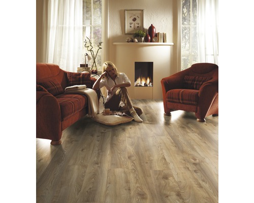 Vardagsrum med laminatgolv, soffa, fåtölj och öppen spis