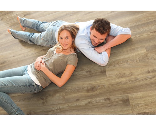 Ett par ligger på ett ljust trälaminatgolv.