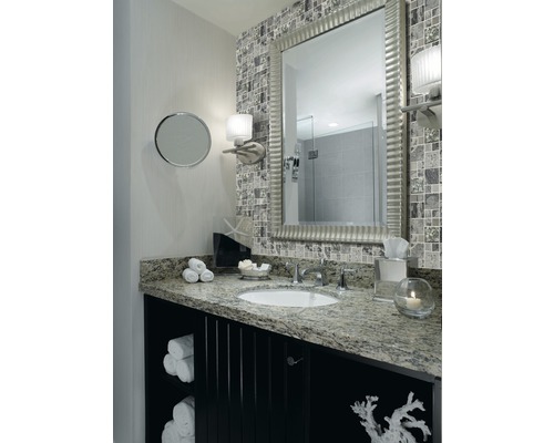 Badrum med spegel, handfat, underskåp och mosaikplattor