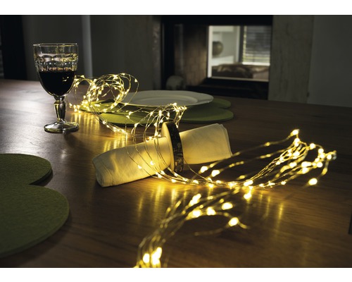 Bordsdekoration med ljusslinga, glas och porslin