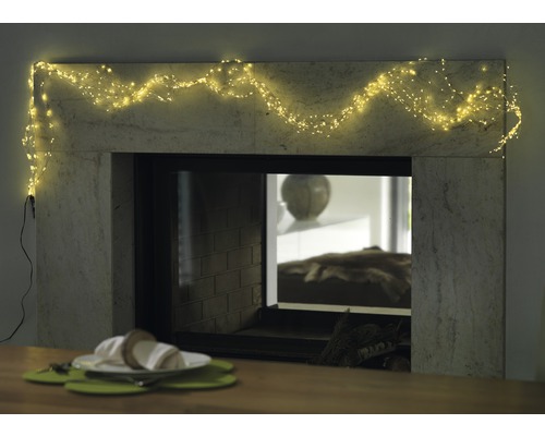 Dekorativ öppen spis med ljusslinga och dukat bord för en mysig atmosfär