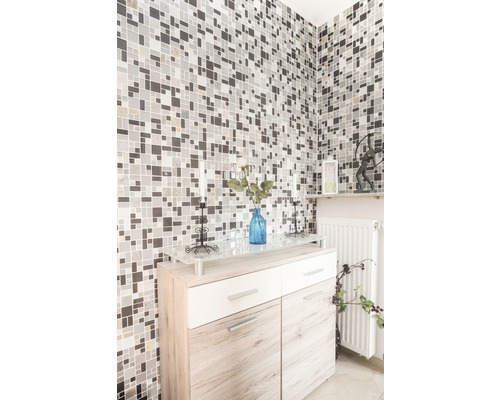 Miljöbild med mosaikvägg, skänk, vas och dekorationer