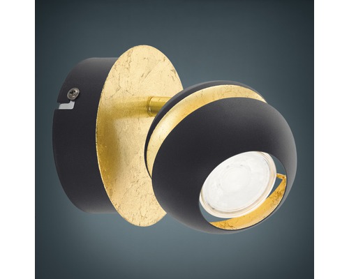 Svängbar vägglampa med rund form och guldfärgad dekoration