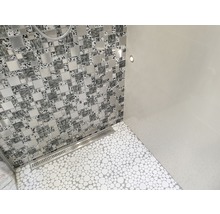 Badrum med mosaikvägg, golvplattor i stenlook och avloppsränna