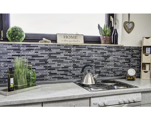 Köksscen med mosaikplattor, vattenkokare i rostfritt stål och dekorativa element.