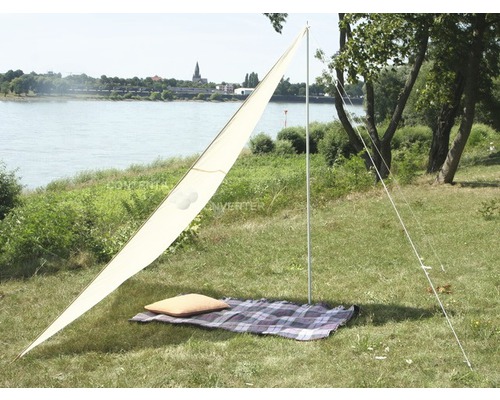 Triangulärt solsegel med spännband på en picknickfilt utomhus